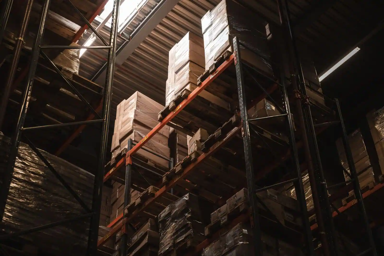 Rayonnages à palettes d'un entrepôt chargés de cartons, vus en contre-plongée