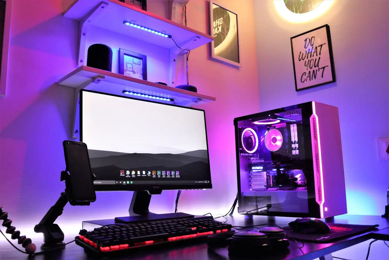 Configuration PC de bureau avec éclairage coloré : écran, clavier et tour aux composants visibles.