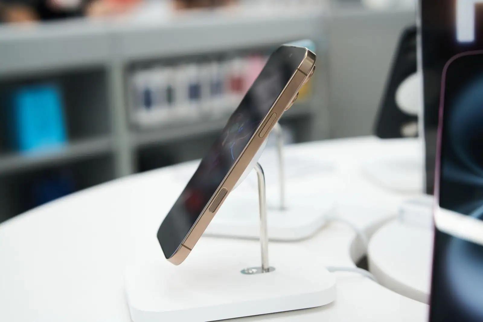 Smartphone récent exposé sur un présentoir, dans un magasin de téléphonie et d'électronique.