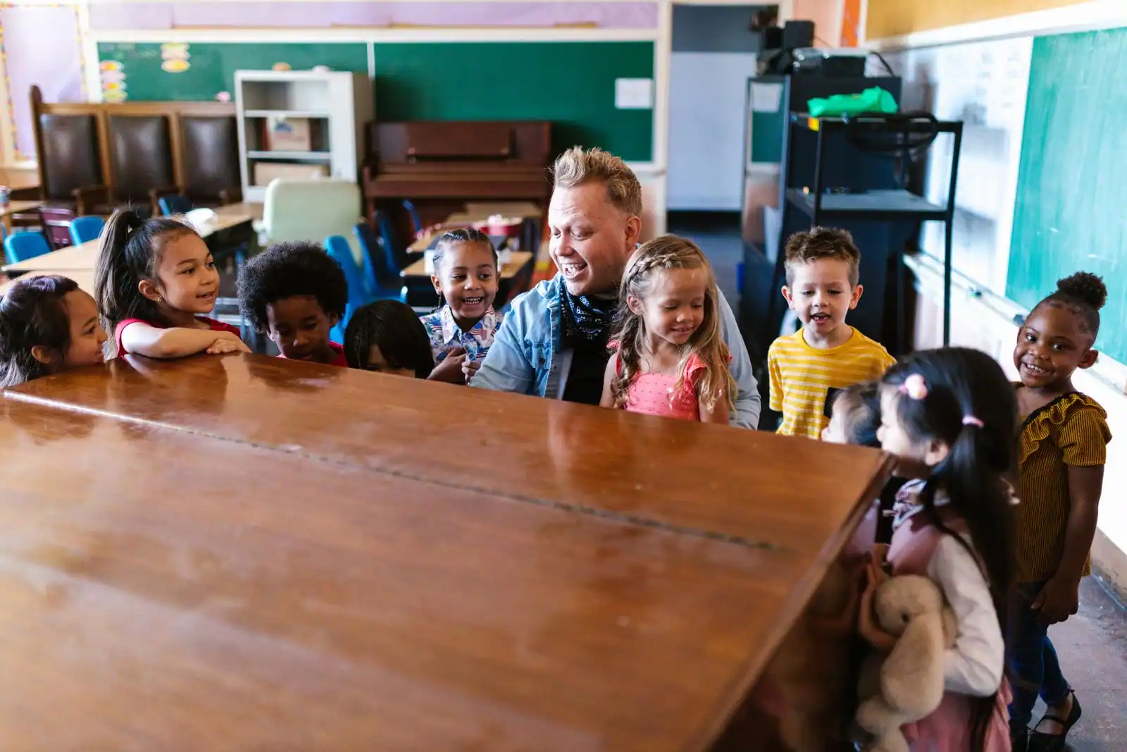 Jeunes enfants regroupés autour d'une table en classe avec leur enseignant