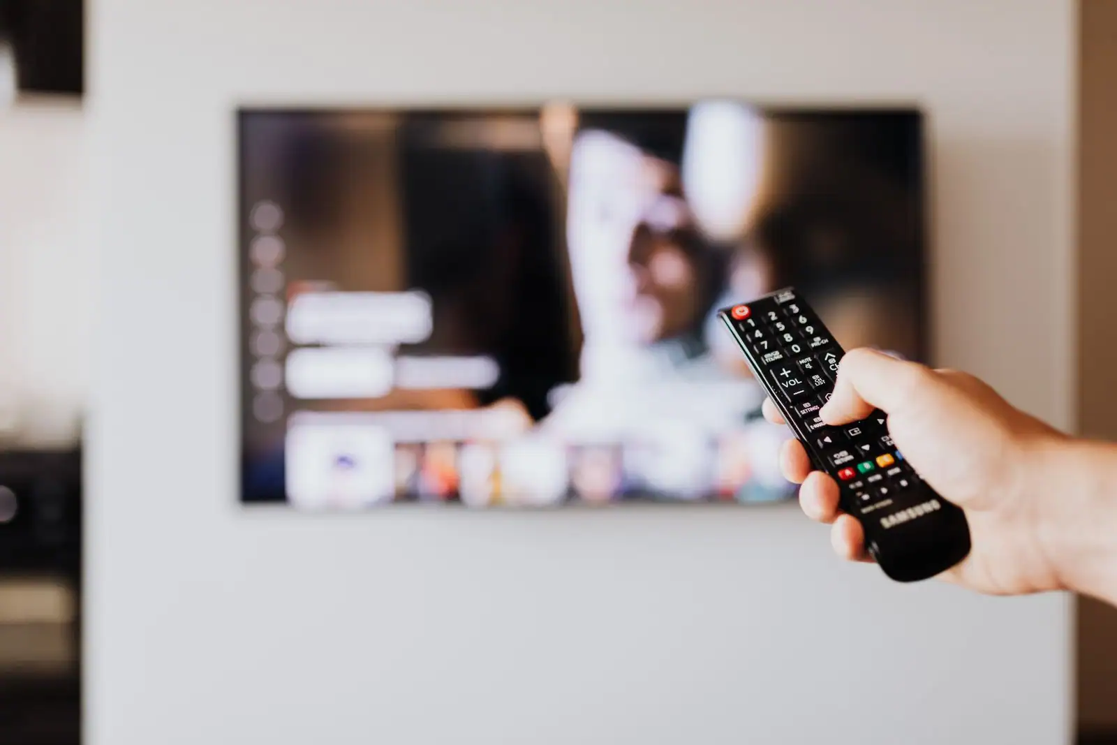 Télécommande pointée vers un téléviseur à écran plat affichant une interface de streaming dans un salon.