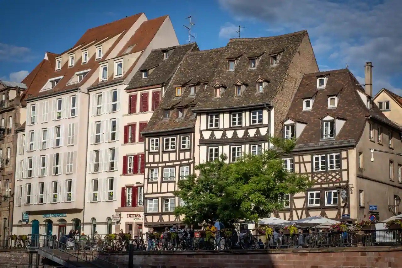 Façades alsaciennes à colombages le long d'une rue animée, illustration de l'architecture typique de la région.