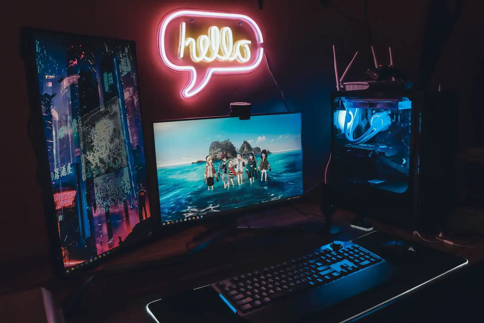 Configuration de jeu PC avec écran allumé, clavier et tour à éclairage bleu dans une pièce sombre