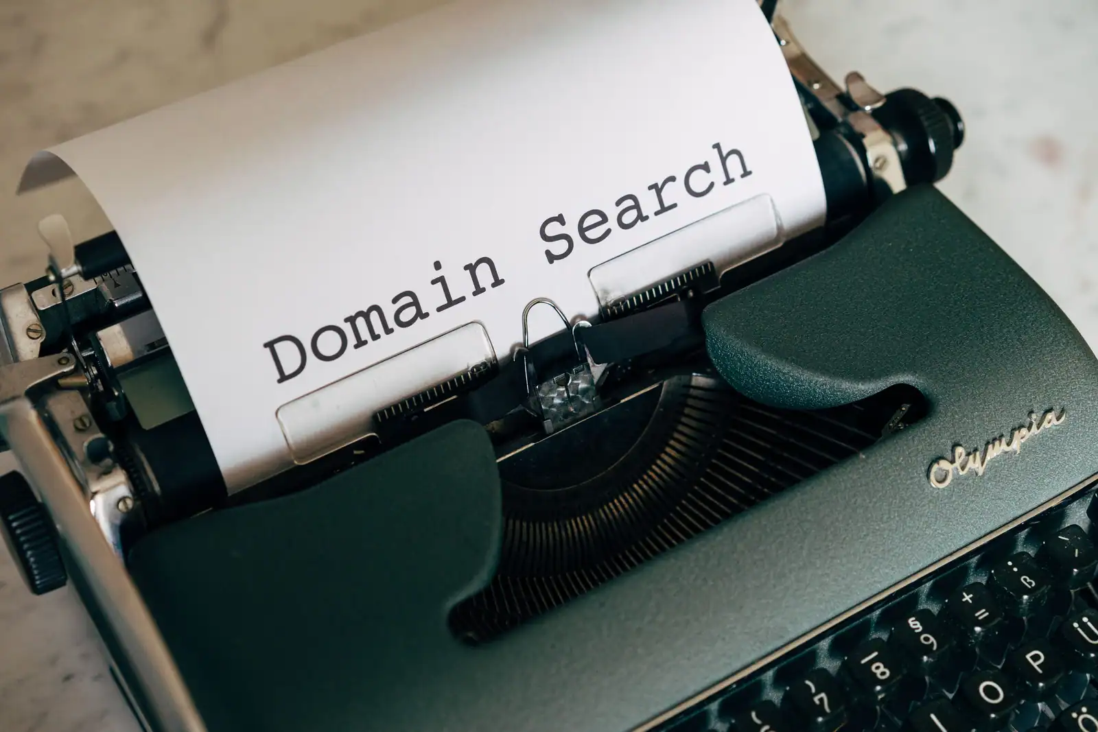 Feuille glissée dans une machine à écrire portant les mots « Domain Search » tapés en gros caractères.