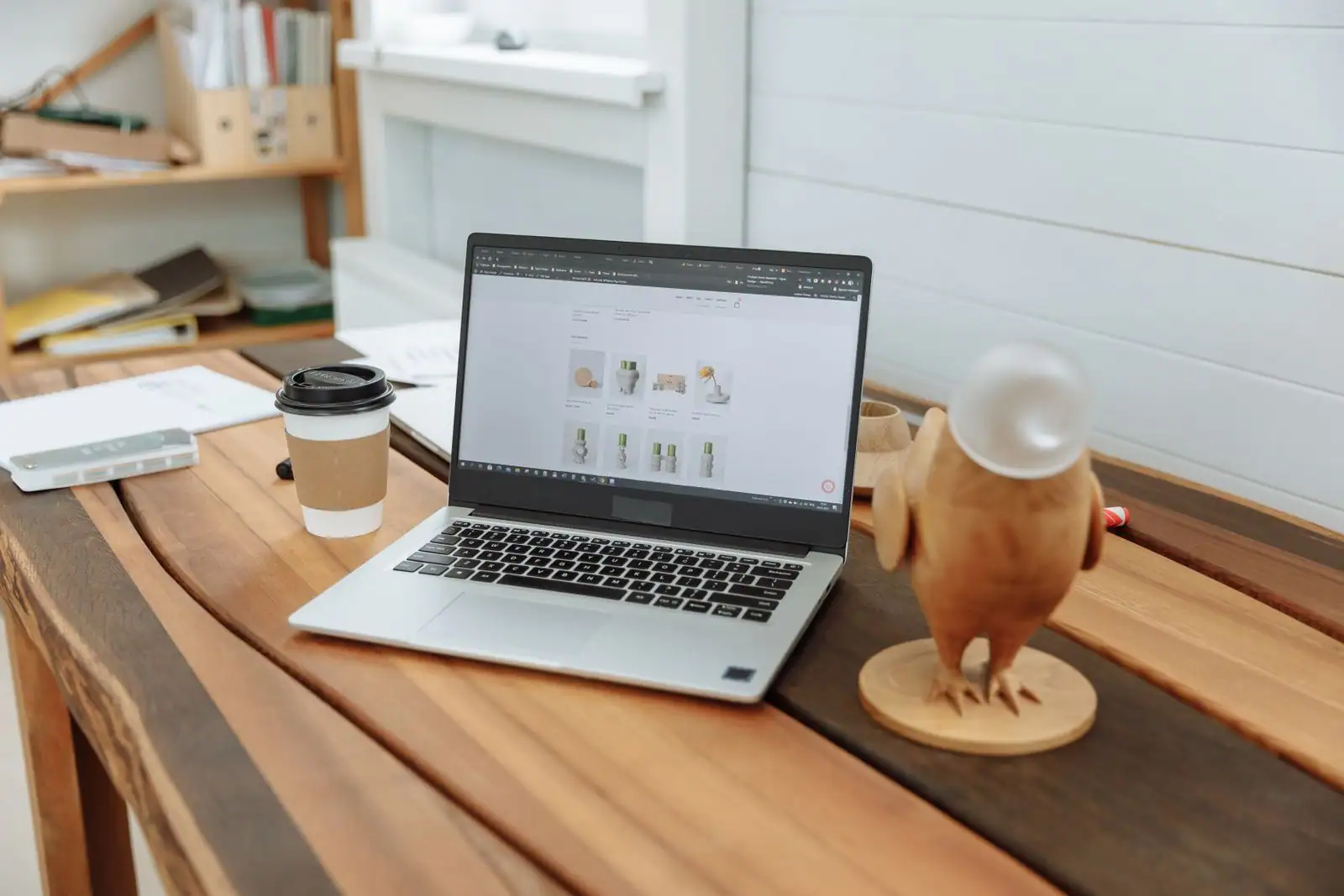 Ordinateur portable sur une table en bois, affichant la page catalogue d'une boutique en ligne.