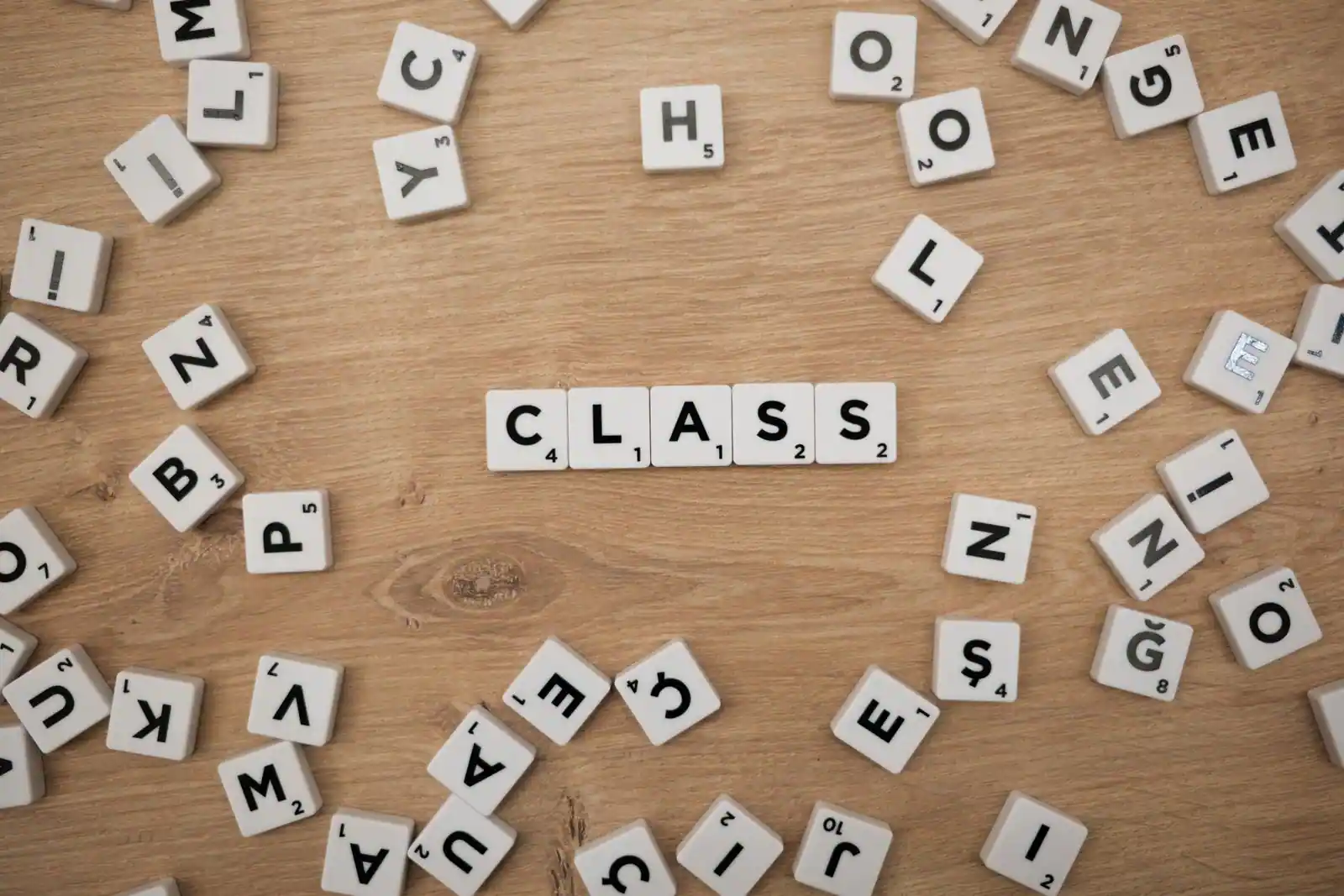 Lettres en bois éparpillées sur une table, comme pour un jeu de mots type petit bac