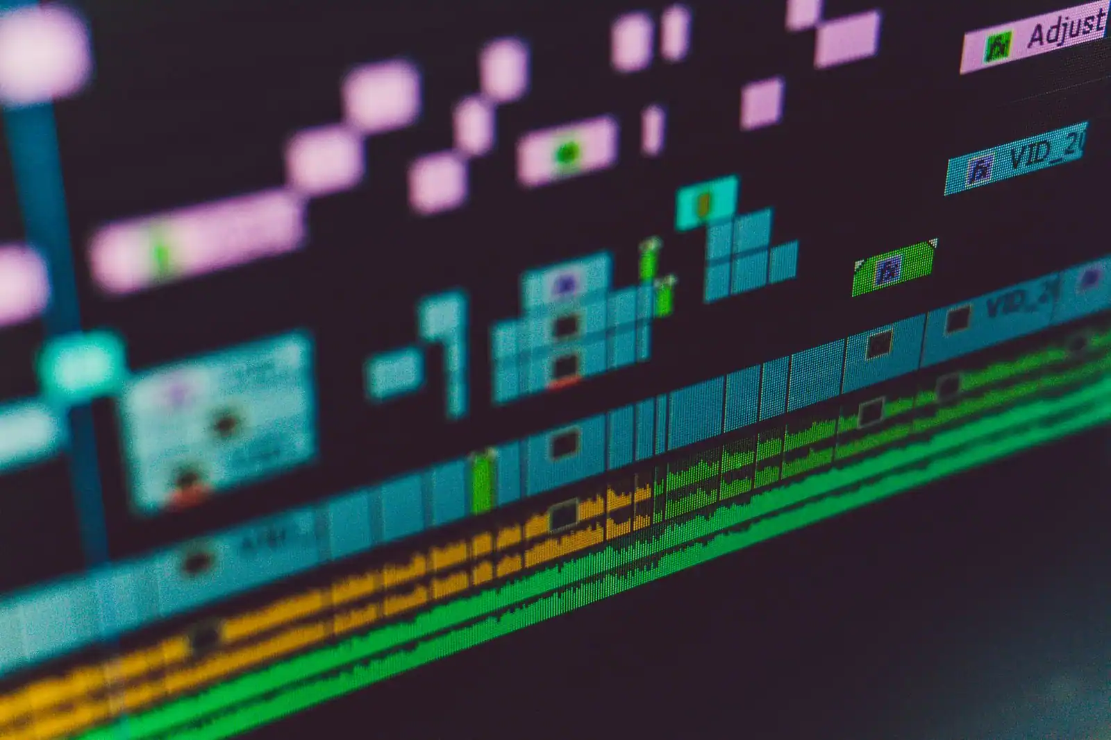Gros plan sur la timeline colorée d'un logiciel de montage vidéo affichée à l'écran