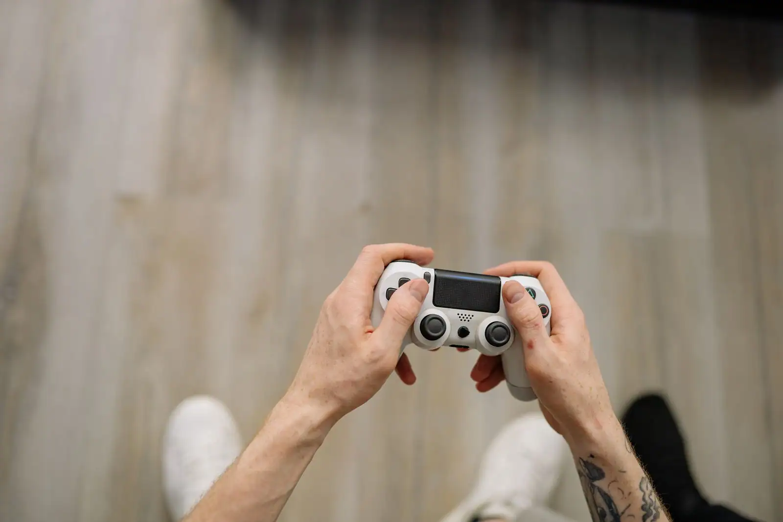 Mains tenant une manette de jeu sans fil, vue de dessus.