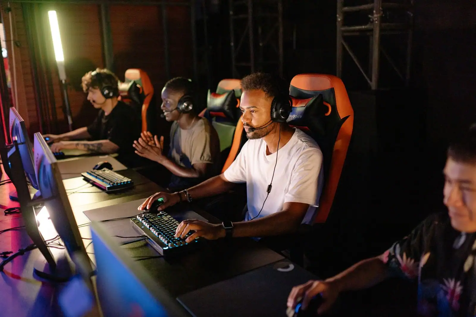 Groupe de joueurs concentrés lors d'un tournoi esport en équipe devant leurs écrans